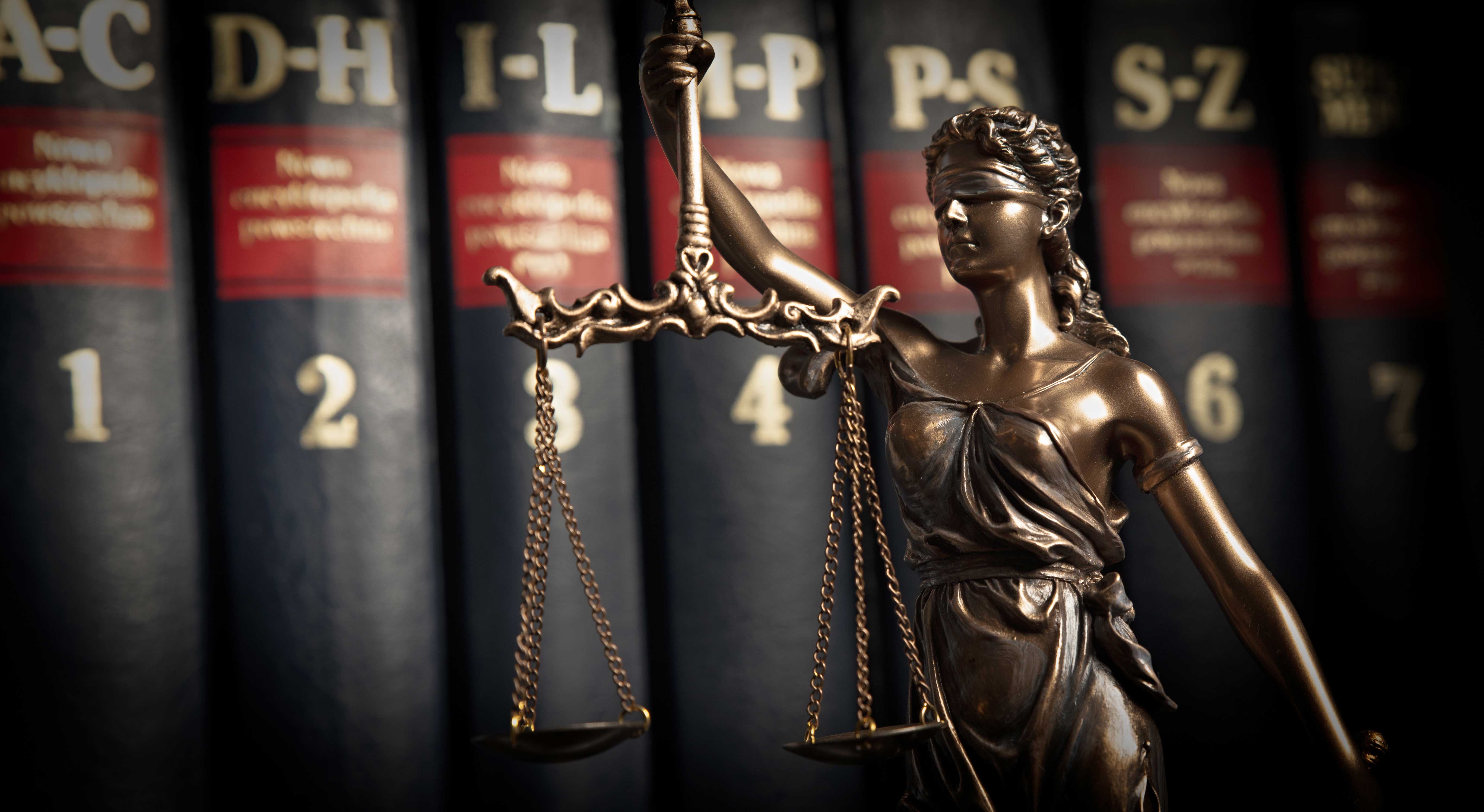 Lady Justice Statue Behind Books