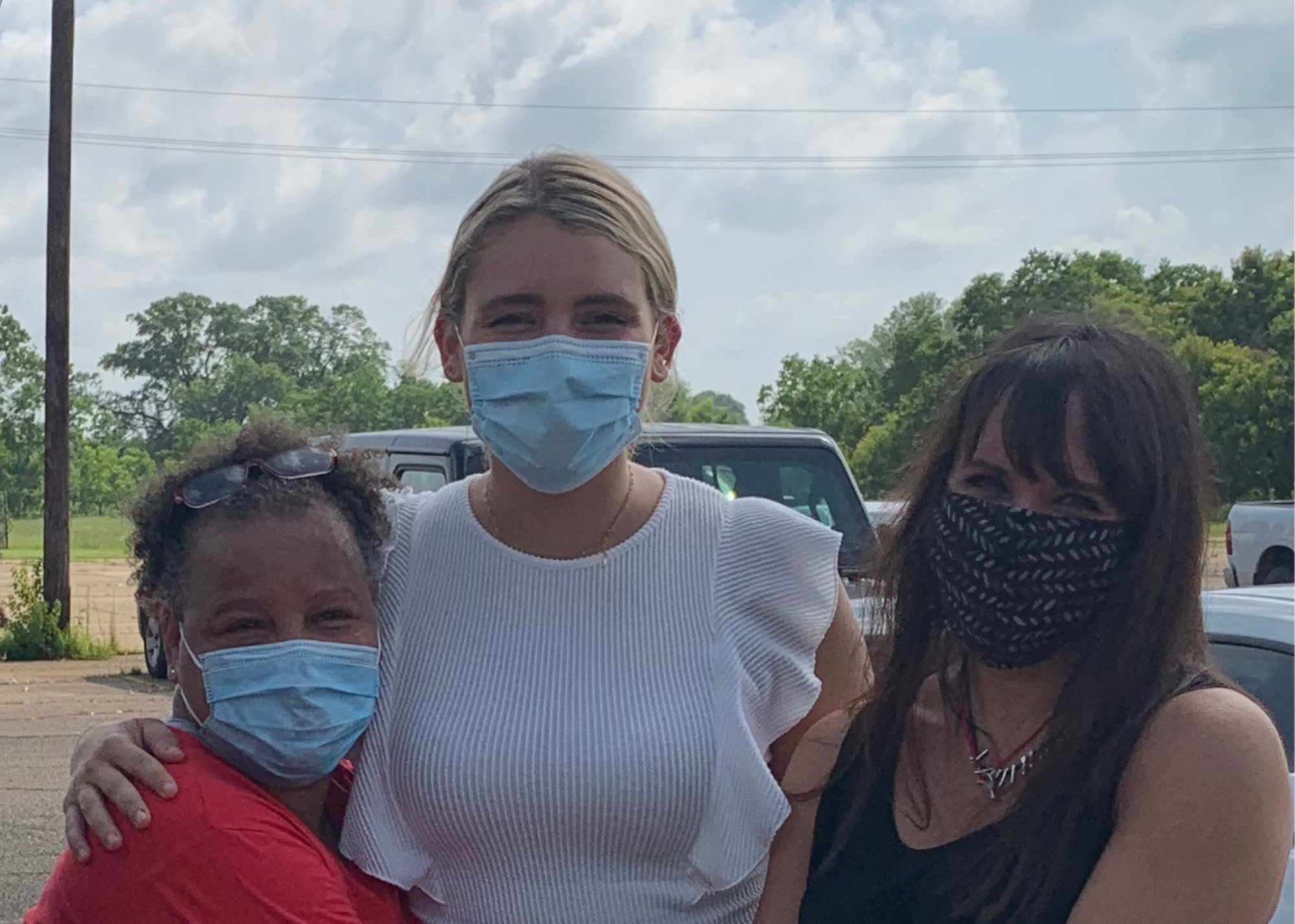 Three masked women embrace outside Louisiana Correctional Institute for Women