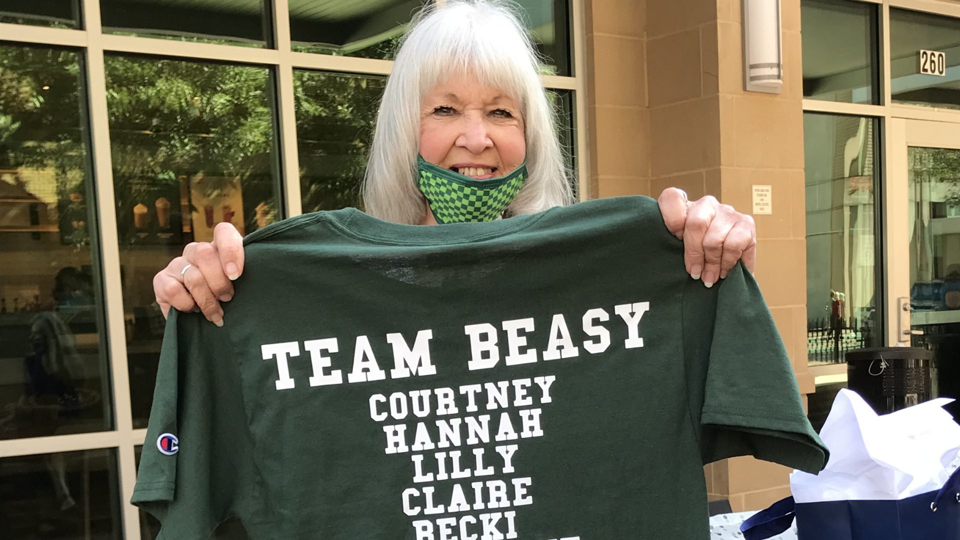 Women's Prison Project client, Beatrice, at Starbucks holding up a "Team Beasy" t-shirt on the day of her release from Louisiana Correctional Institute for Women.