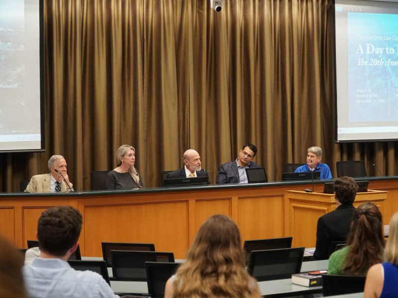 Panelists sit at the front of Room 110, engaged in discussion.