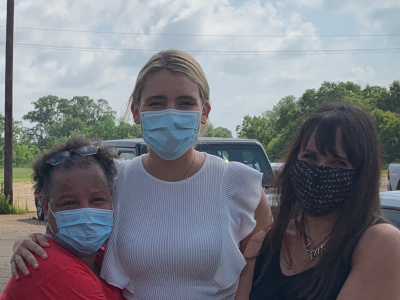 Three masked women embrace outside Louisiana Correctional Institute for Women