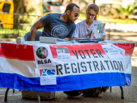 Students man a voter registration booth on campus