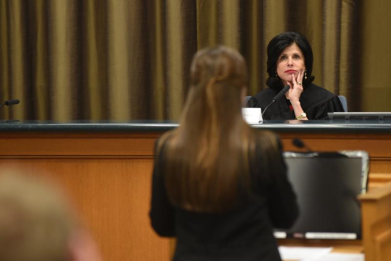 Sarah Vance listens to an individual in a courtroom.