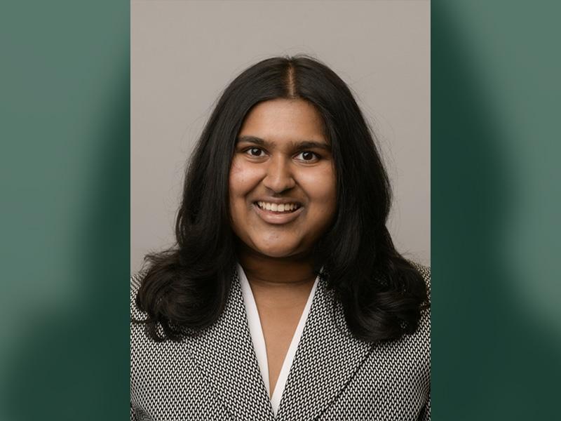 Navya Kolli smiles for a professional headshot.